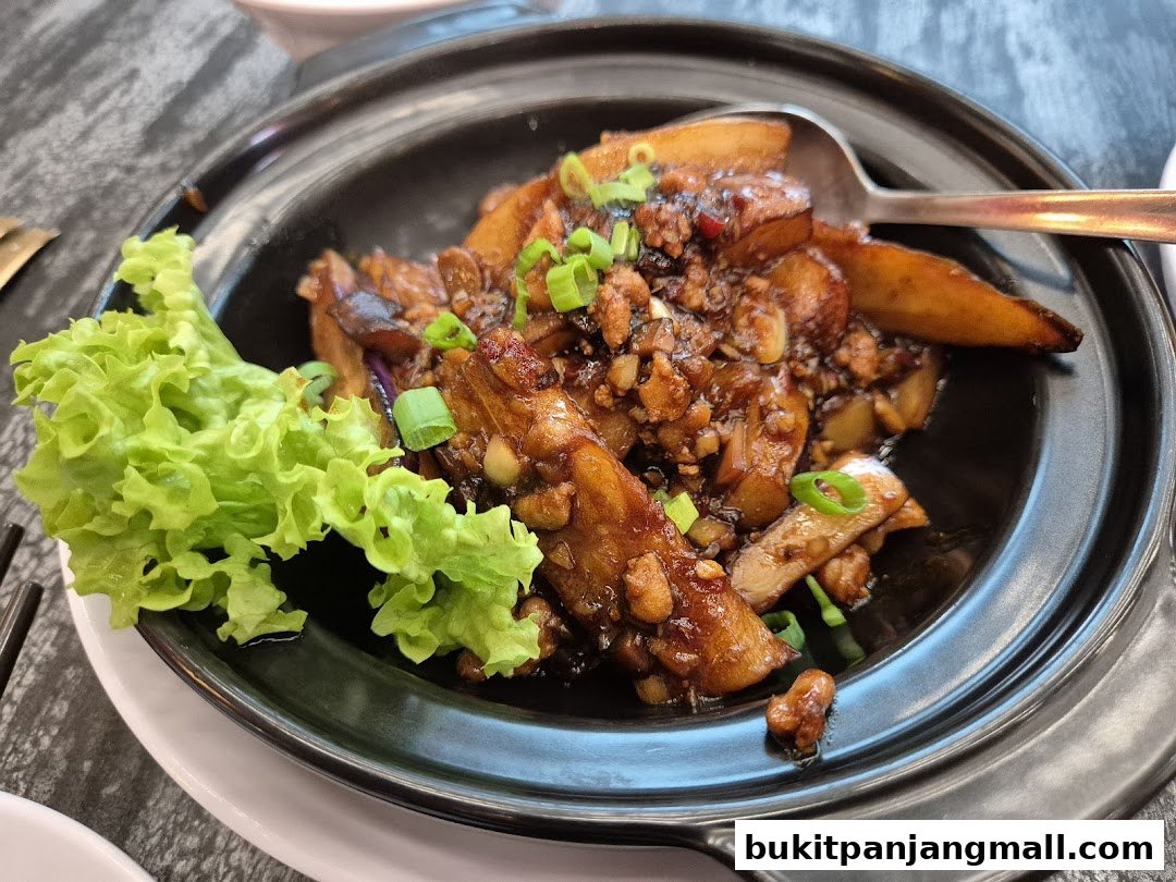 A close-up shot of a savory dish with eggplant, minced meat, and scallions, served with lettuce.