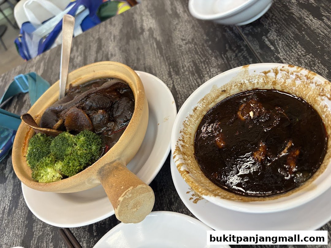 Two bowls of rich, dark stew with meat and broccoli, served in a restaurant.