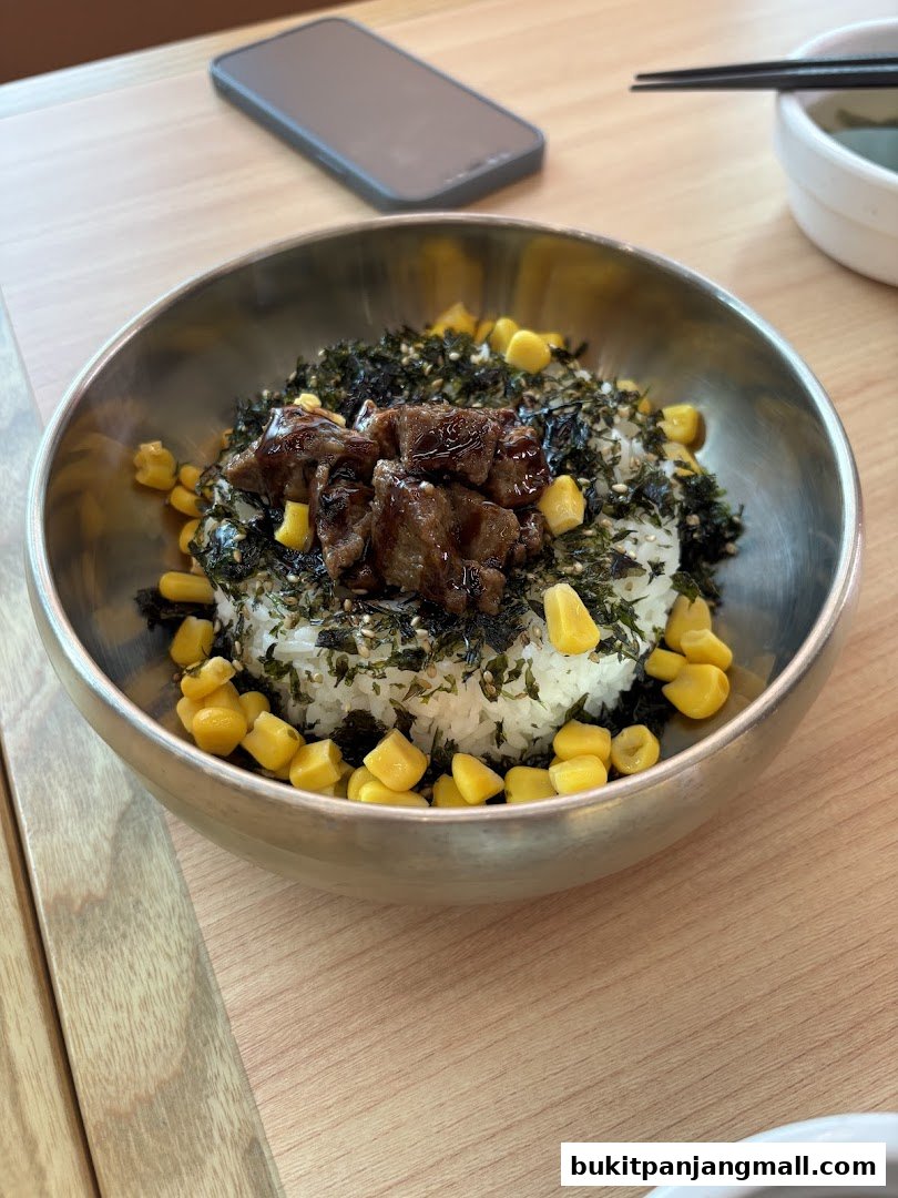 A close-up of a delicious bibimbap dish with beef, corn, and seaweed.