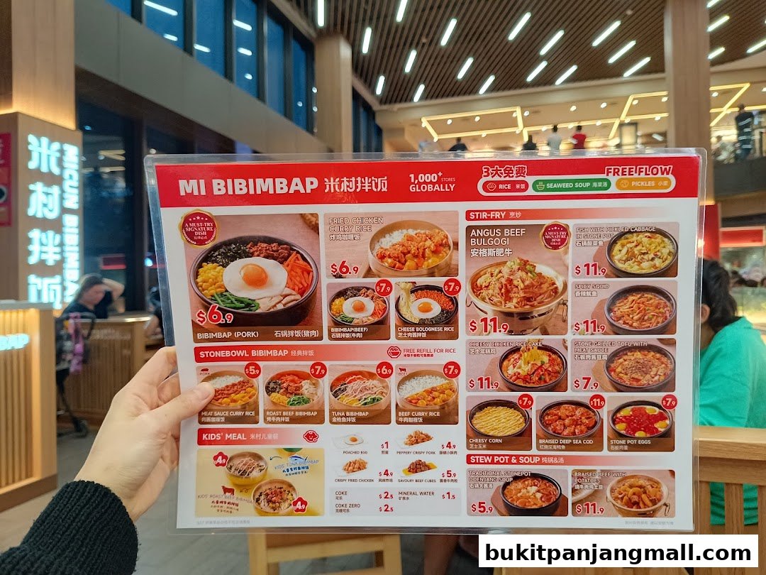 A person holds a menu for Micun Bibimbap, showcasing various Korean dishes with prices.