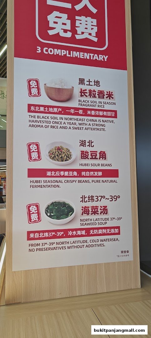 A sign displays three complimentary dishes: fragrant rice, sour beans, and seaweed soup.