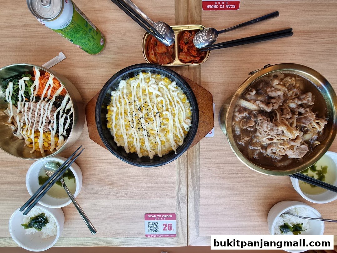A table setting with Korean dishes, including bibimbap, a corn dish, and a beef stew.