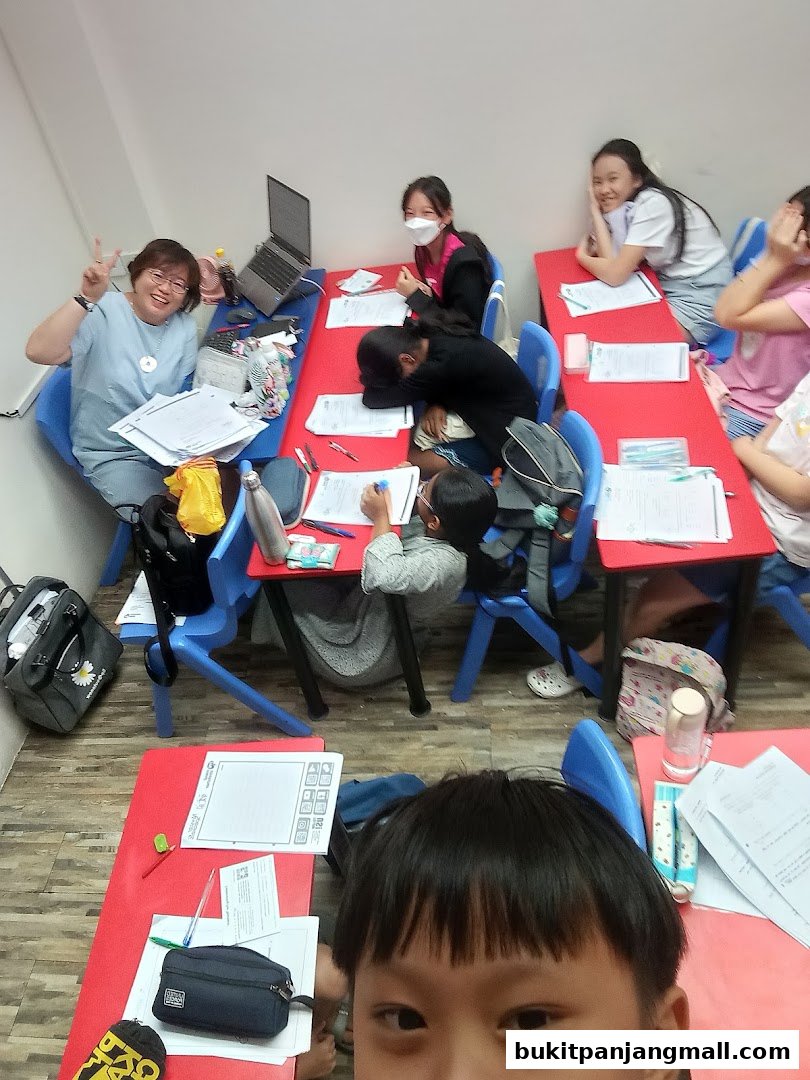 A teacher and students are in a classroom setting, engaged in learning activities.