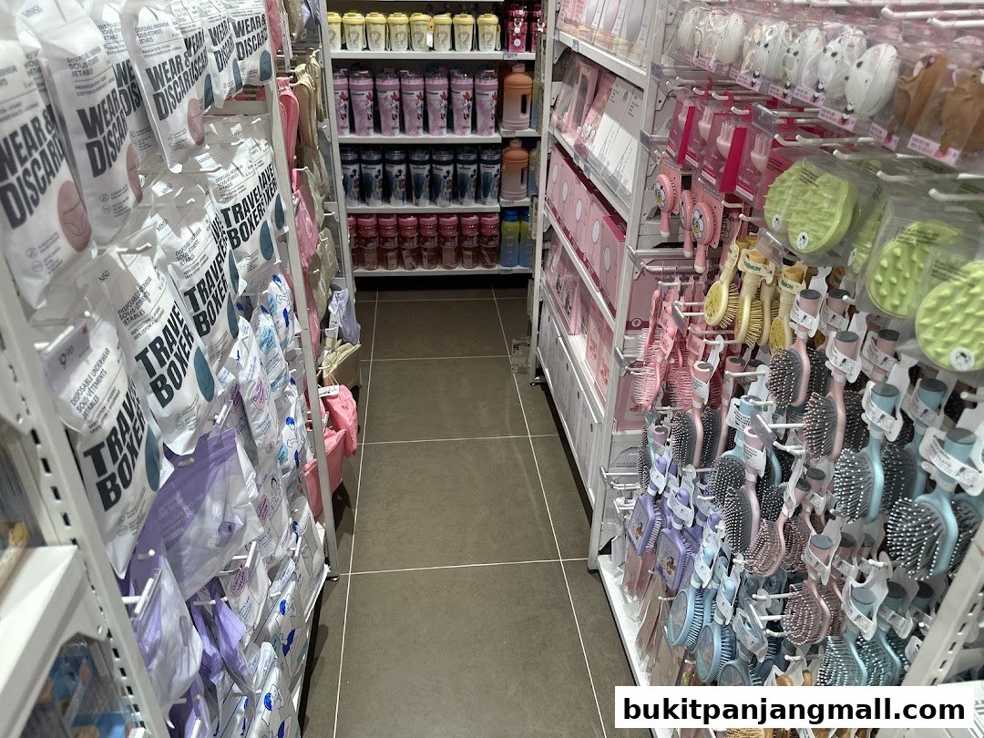 A wide aisle in a Miniso store showcasing travel essentials and hair accessories.