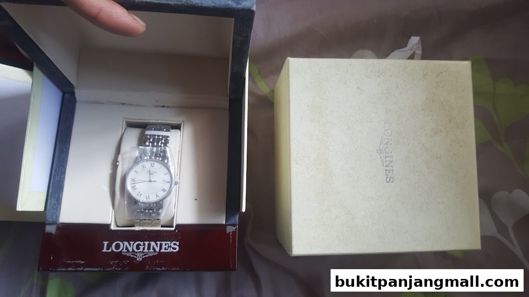 A Longines watch displayed in its box next to its packaging.