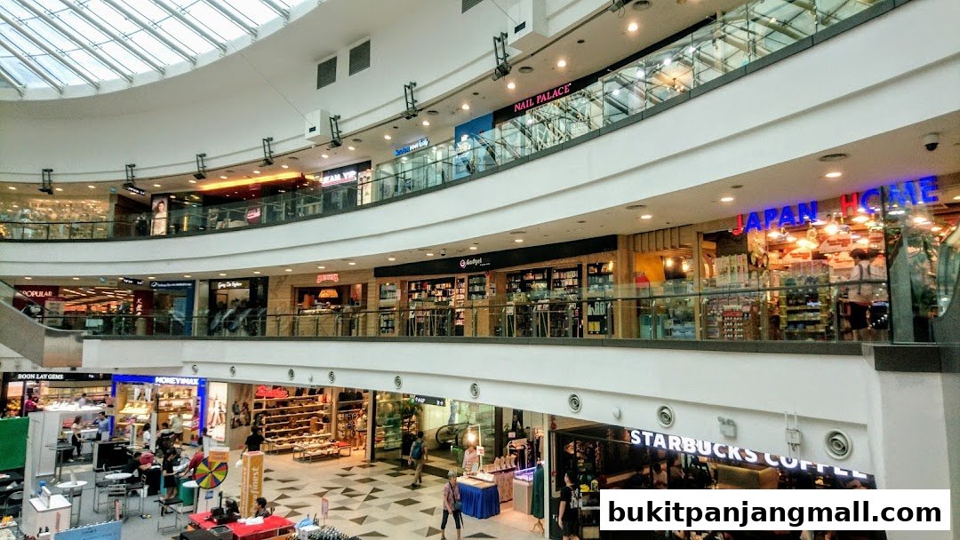 A multi-level shopping mall interior with various shops and escalators visible.