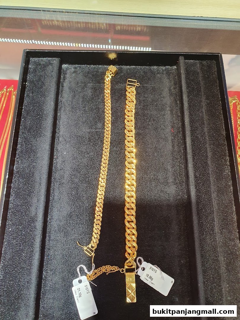 Two gold bracelets displayed on a black velvet tray with price tags.