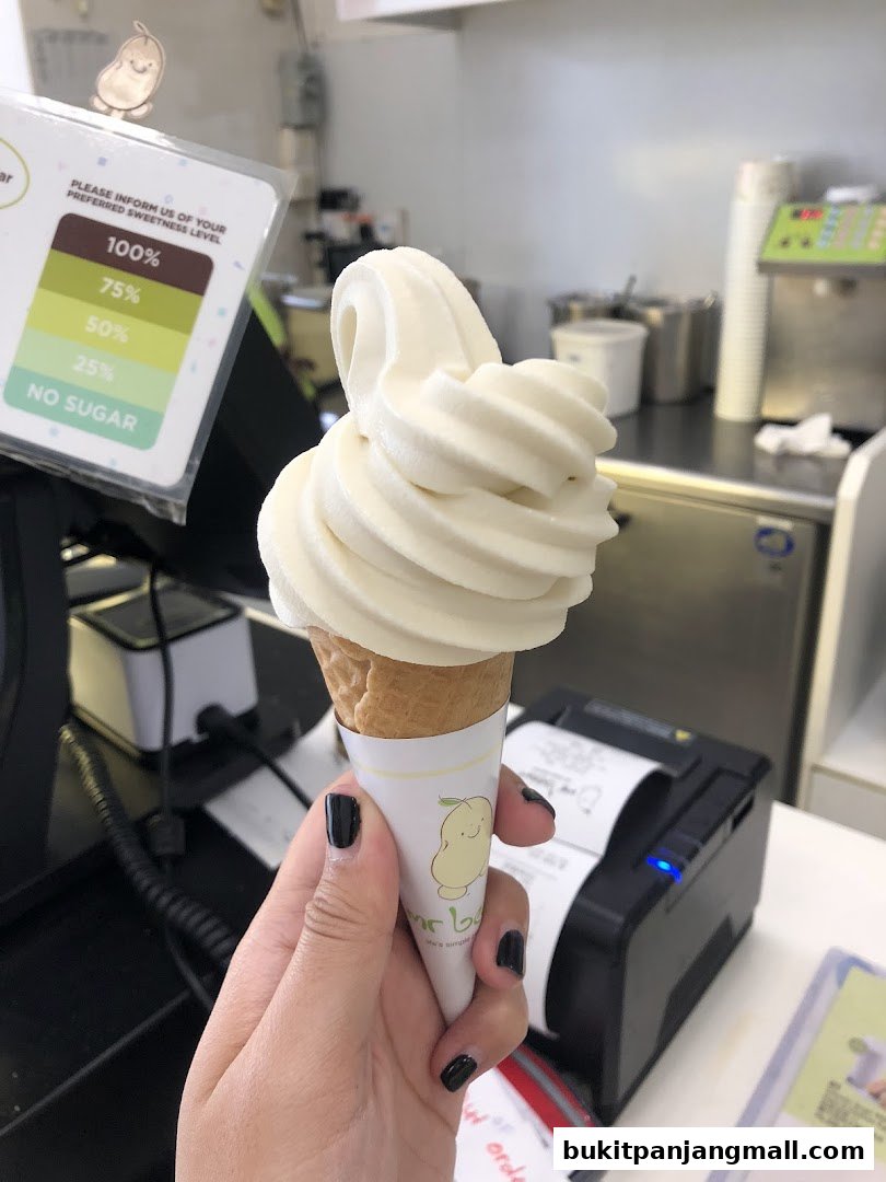 A hand holds a soft-serve ice cream cone with a sweetness level chart in the background.