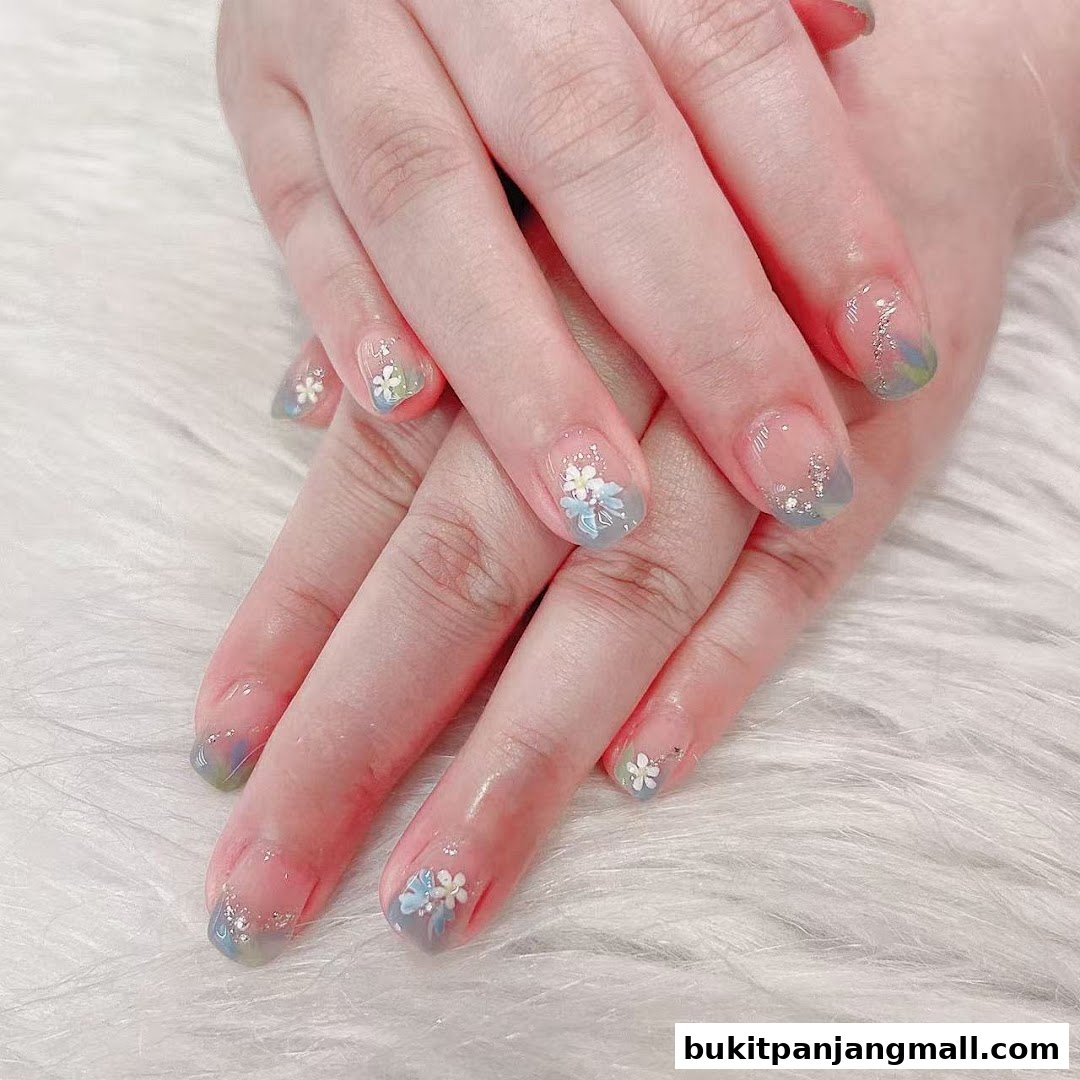 Close-up of hands with delicate floral nail art and subtle glitter.