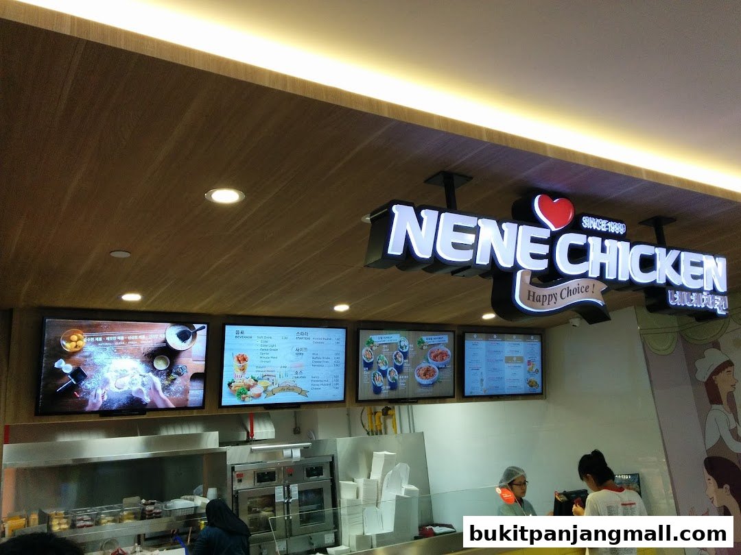 NeNe Chicken shop interior with digital menus and staff serving customers.