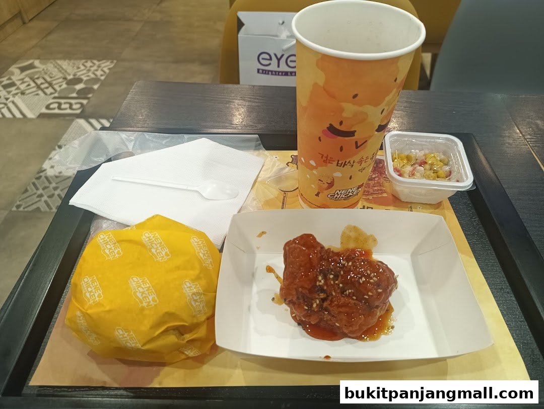 A tray of NeNe Chicken food including a burger, fried chicken, a drink, and a side of corn.