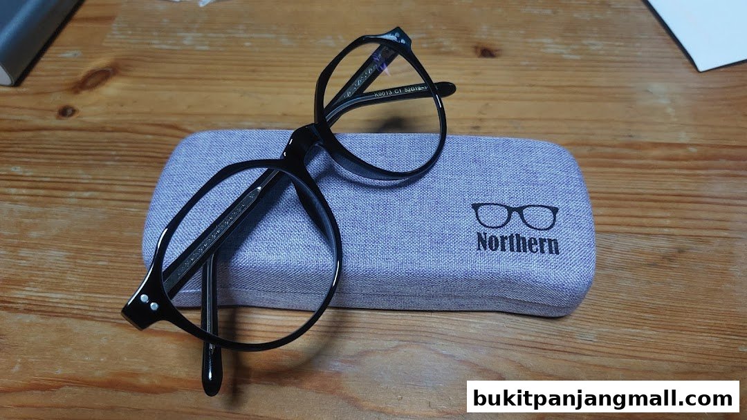 A pair of black eyeglasses rests on a textured glasses case with the Northern Opticians logo.