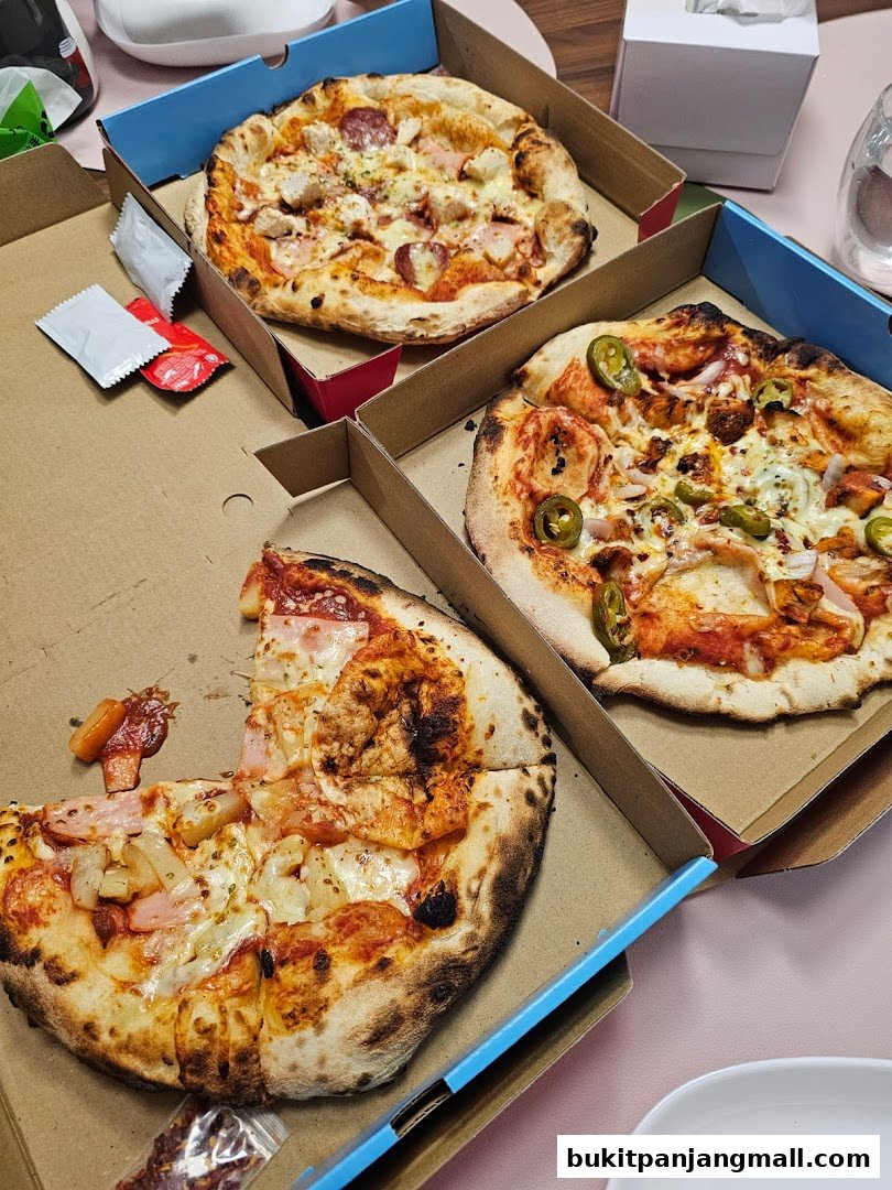 Three delicious pizzas in their boxes, ready to be enjoyed.