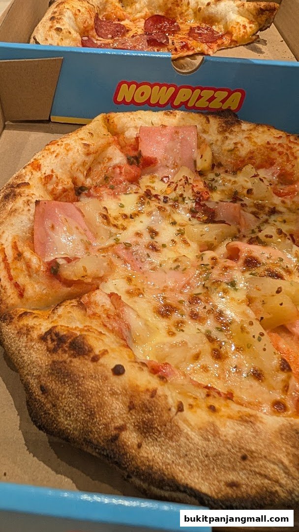 Two delicious pizzas, one with pepperoni and another with ham and pineapple, in their boxes.