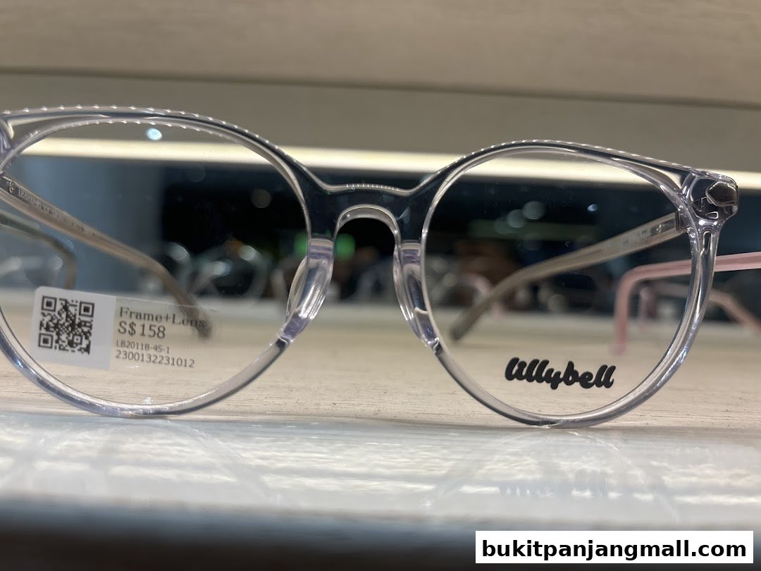 A close-up of clear-rimmed glasses with a price tag and brand name visible.