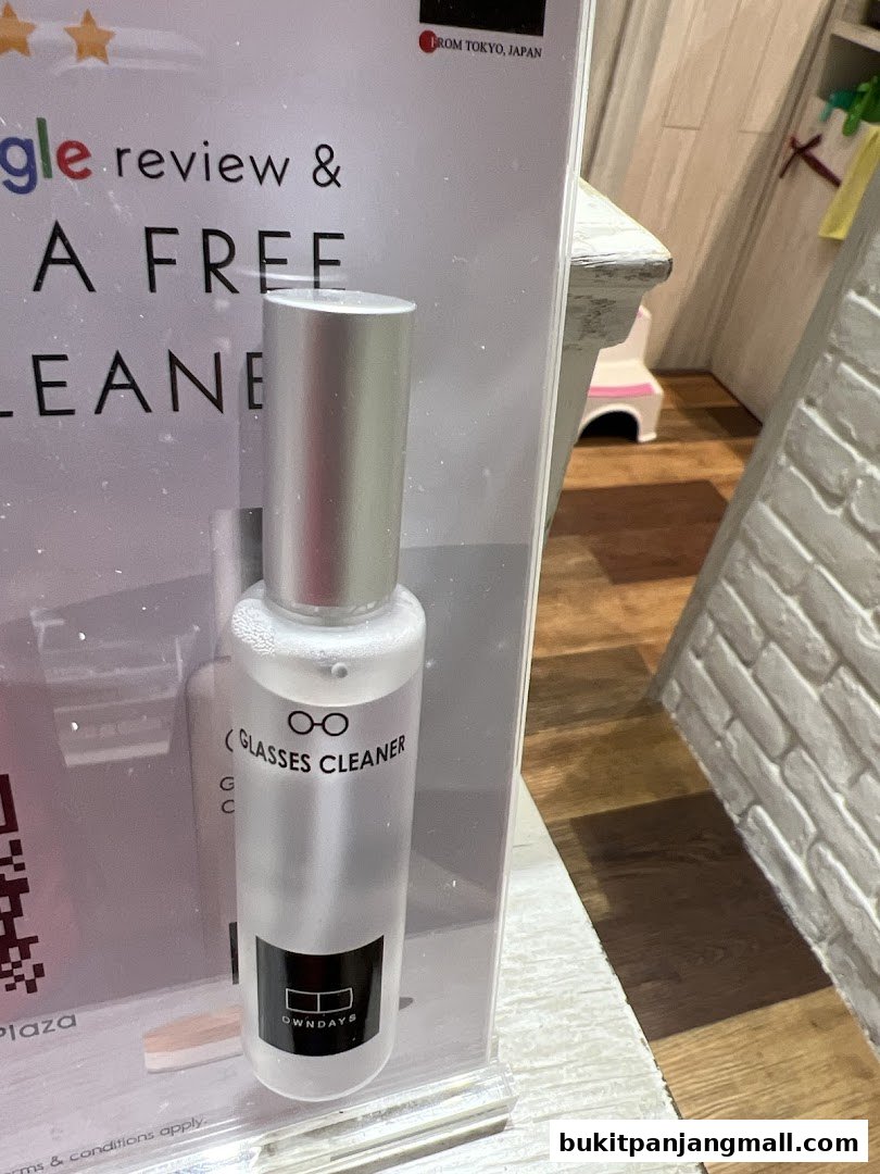 A bottle of OWNDAYS glasses cleaner displayed with a promotion for a free cleaner.