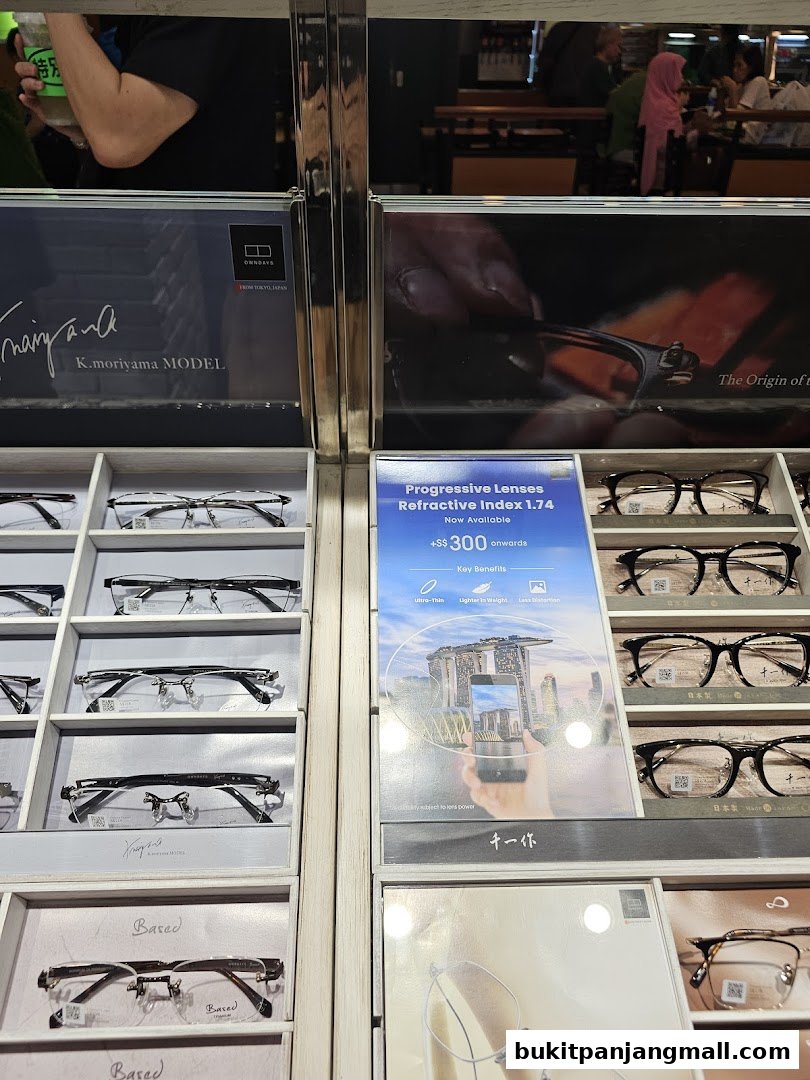 A display of various eyeglasses and a promotional poster for progressive lenses at OWNDAYS.