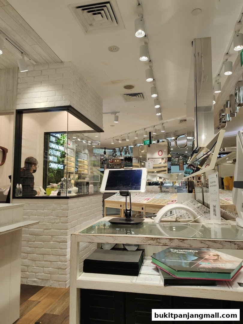 Interior view of an optical shop with display shelves and a tablet.
