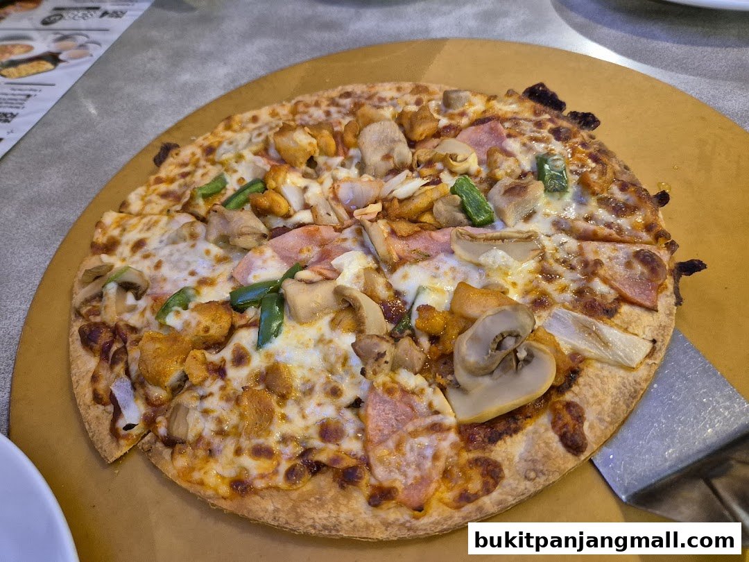 A delicious pizza with various toppings, including chicken, mushrooms, and green peppers, served on a wooden board.