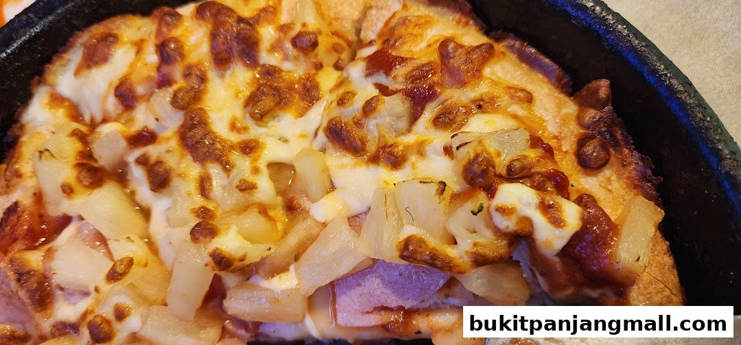 A close-up shot of a delicious Hawaiian pizza with melted cheese and pineapple chunks.
