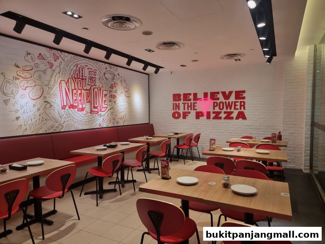 Interior of a Pizza Hut restaurant with red seating and tables set for dining.