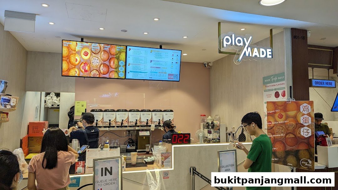 Interior of a PlayMade shop with customers ordering and staff preparing drinks.
