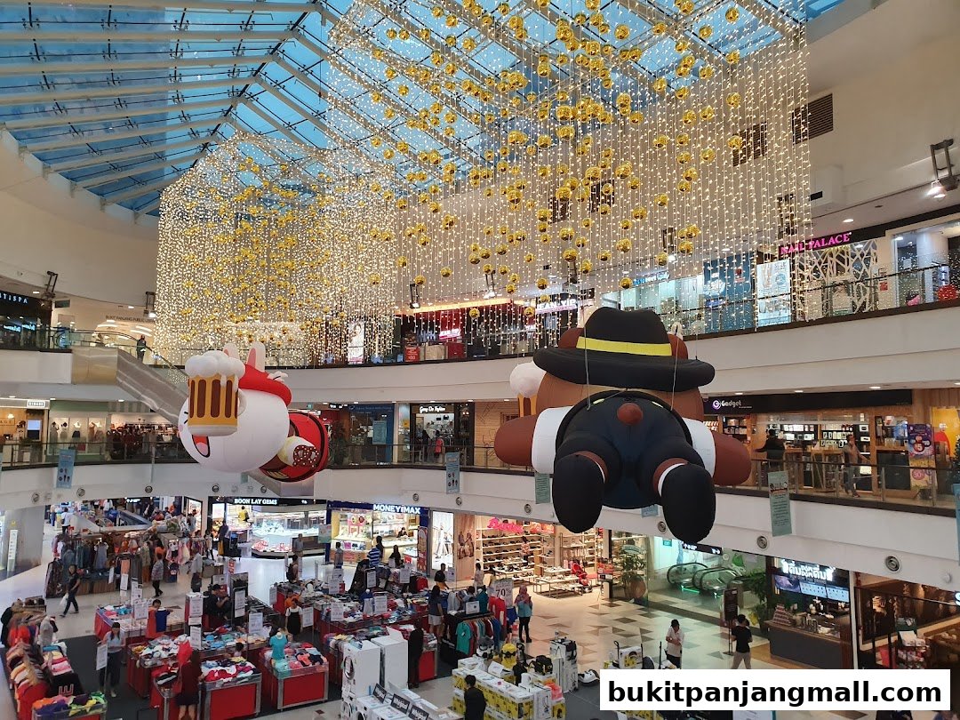 A festive mall interior with large inflatable characters and sparkling lights hanging from the ceiling.