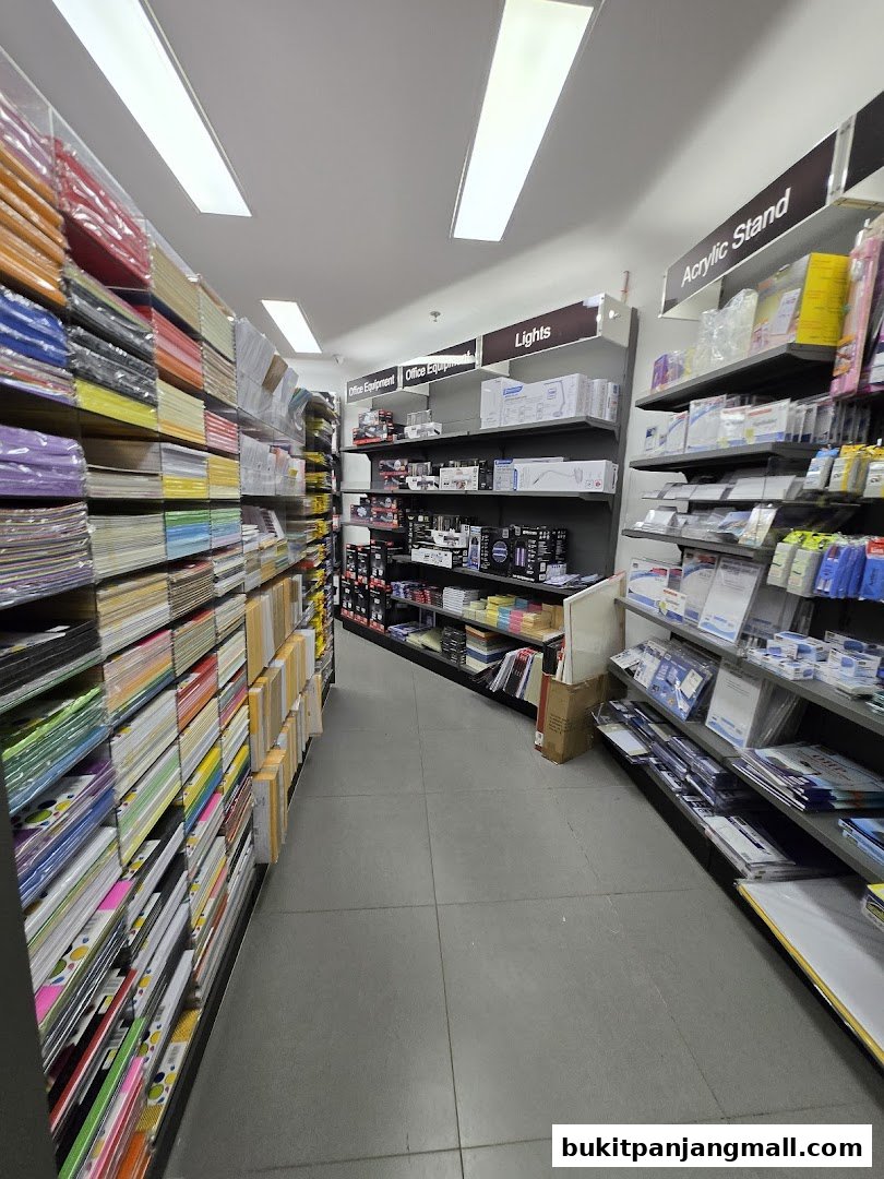 A wide aisle in a store filled with shelves of stationery and office supplies.