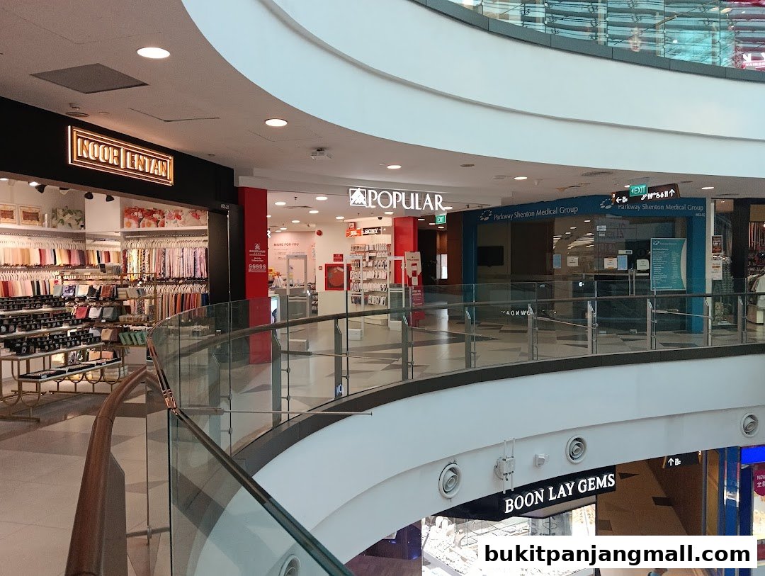 A view of a shopping mall interior showing various shop fronts including POPULAR Bookstore.