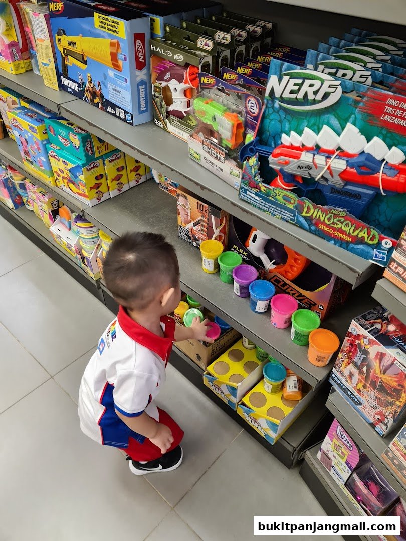 A young child is looking at shelves stocked with toys, including Nerf guns and Play-Doh.