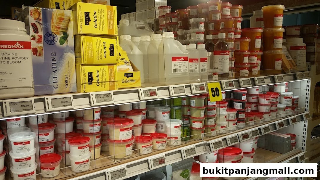 Shelves stocked with various baking ingredients like gelatine, pectin, and powders.