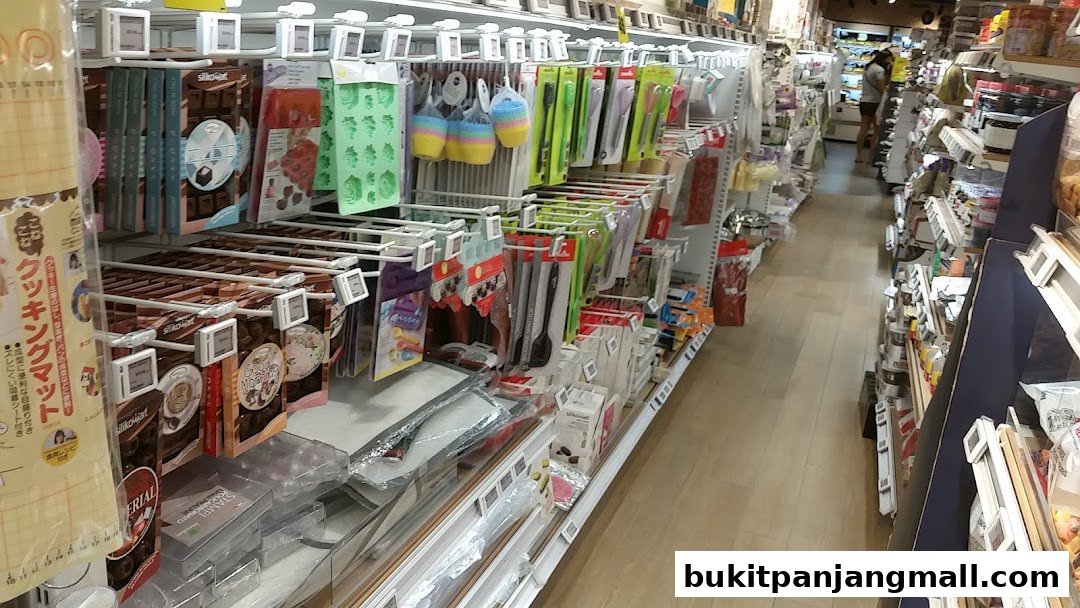 Aisle view of a baking supplies store with shelves stocked with various baking tools and ingredients.
