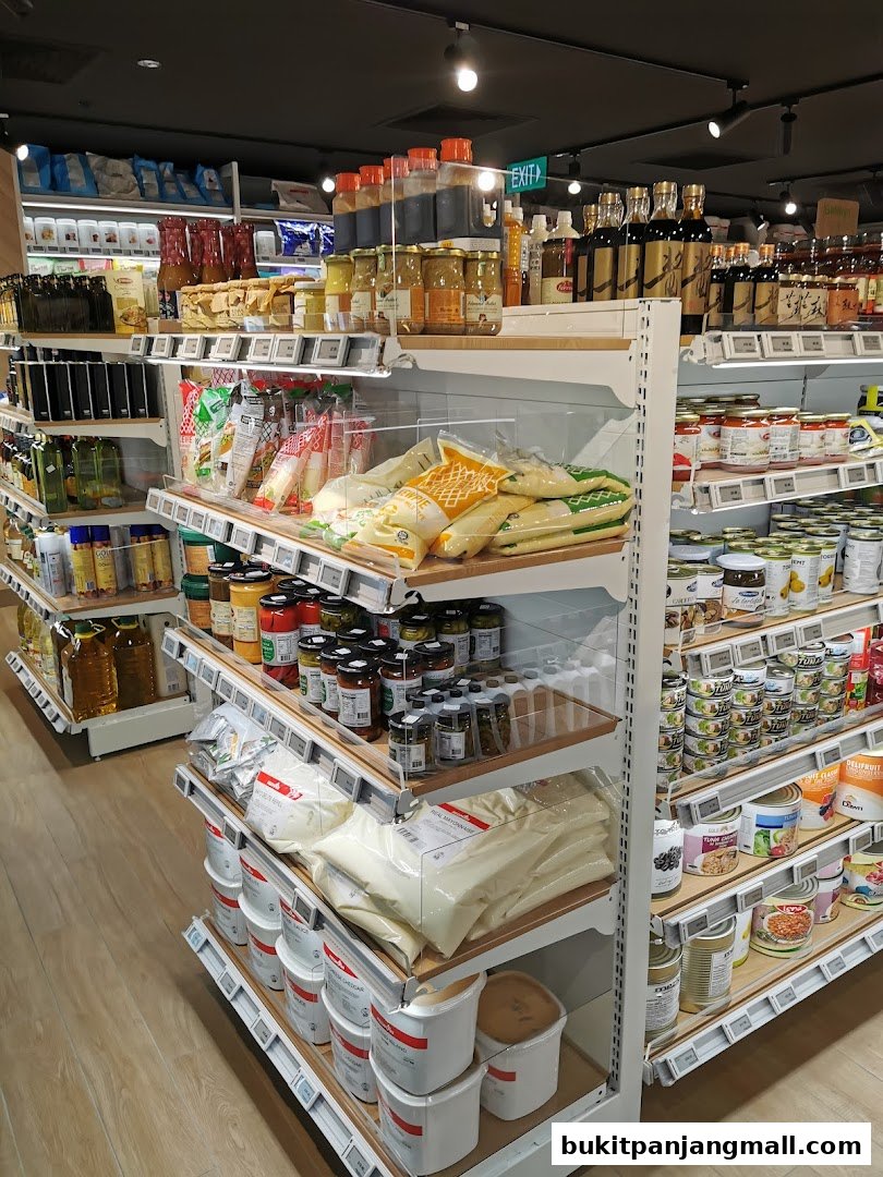 Shelves stocked with various food products, including sauces, jars, cans, and bags of ingredients.