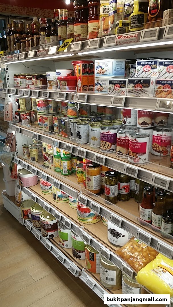 Shelves stocked with various canned goods, including pie fillings, sardines, and other food items.