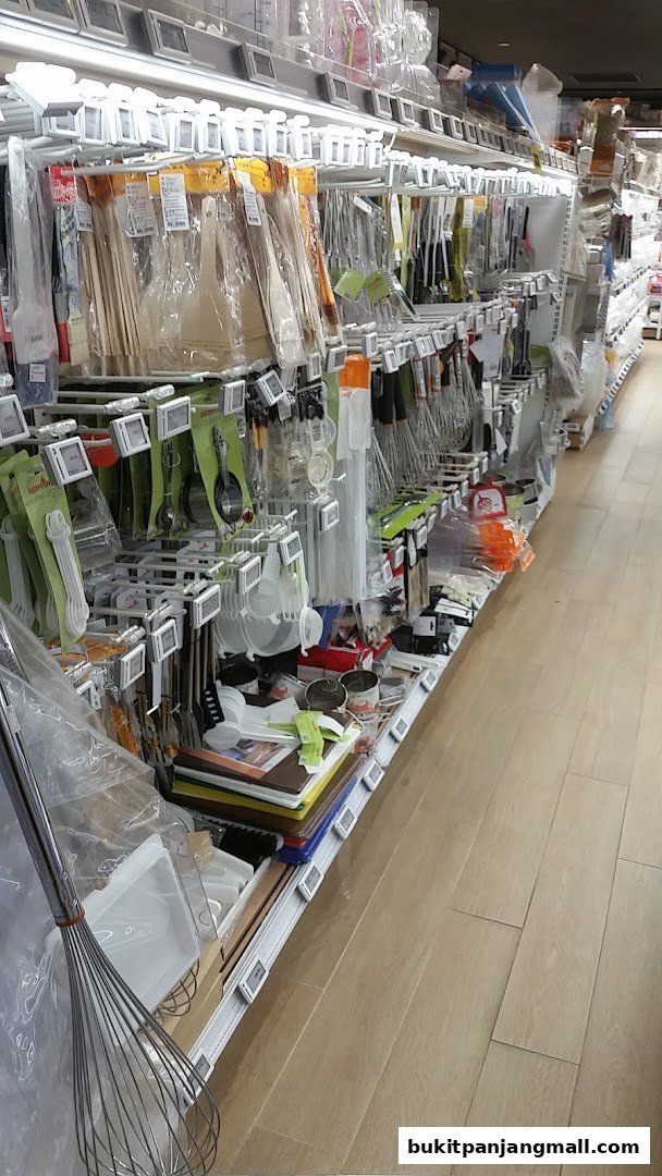 A wide selection of kitchen utensils and baking tools displayed on shelves in a retail store.