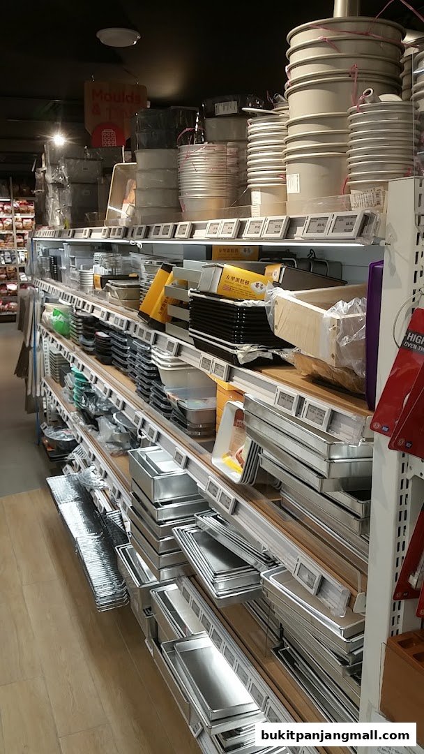A wide selection of baking pans and molds are neatly displayed on shelves in a retail store.