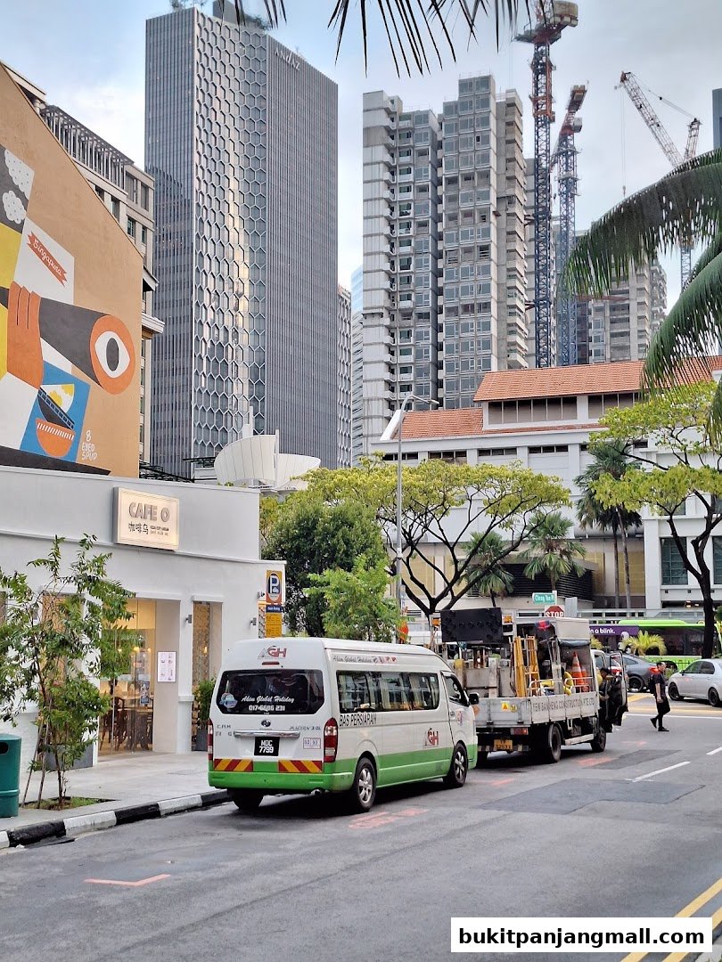 A street scene with a cafe, a van, and construction in the background.