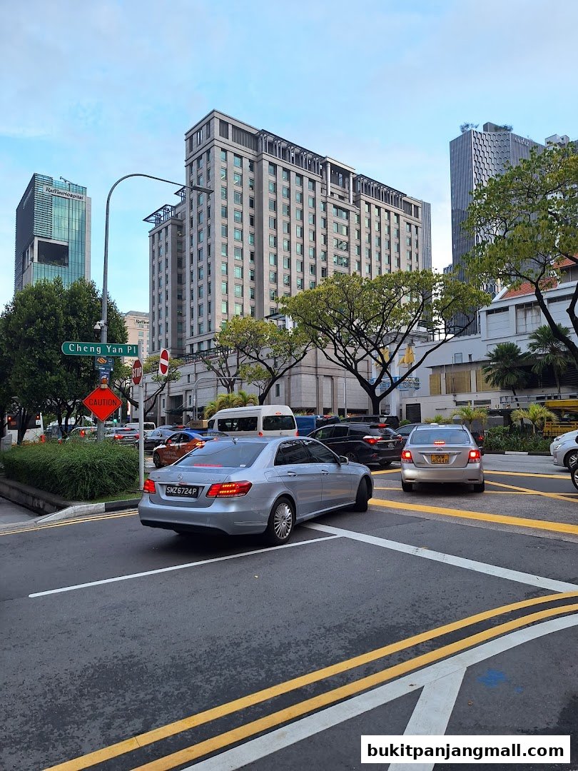 A street view with cars and buildings, including a sign for Cheng Yan Pl.