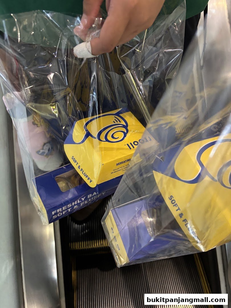 A person holding plastic bags containing yellow and blue boxes with the 'rrooll' logo.