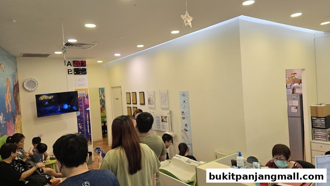 People waiting in a brightly lit clinic with colorful wall art and a reception desk.