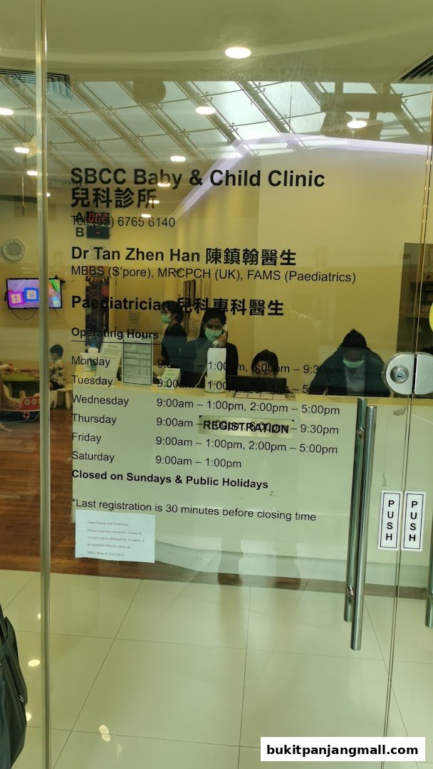 The entrance of SBCC Baby & Child Clinic with operating hours and doctor's information displayed on the glass.