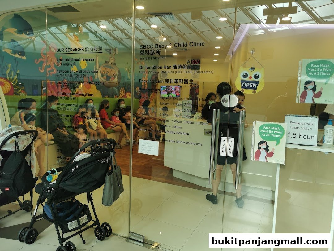 Interior view of a baby and child clinic waiting area with families and strollers.