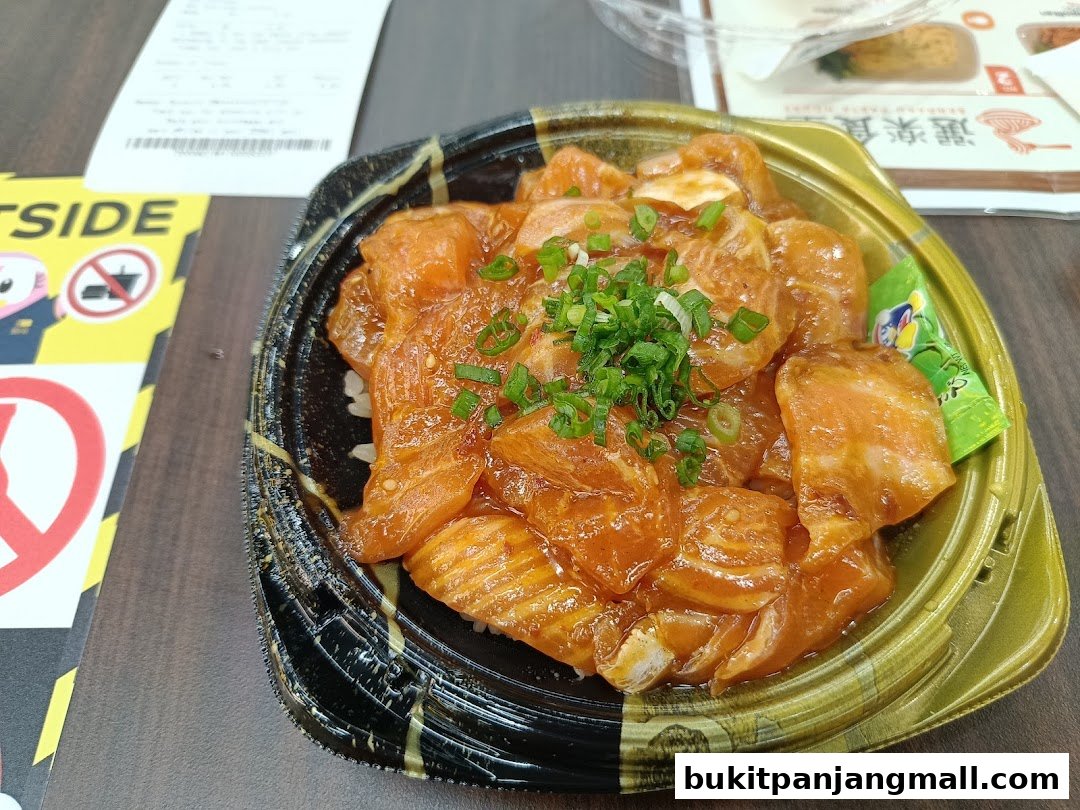 A close-up of a take-out container filled with salmon poke over rice, garnished with green onions.