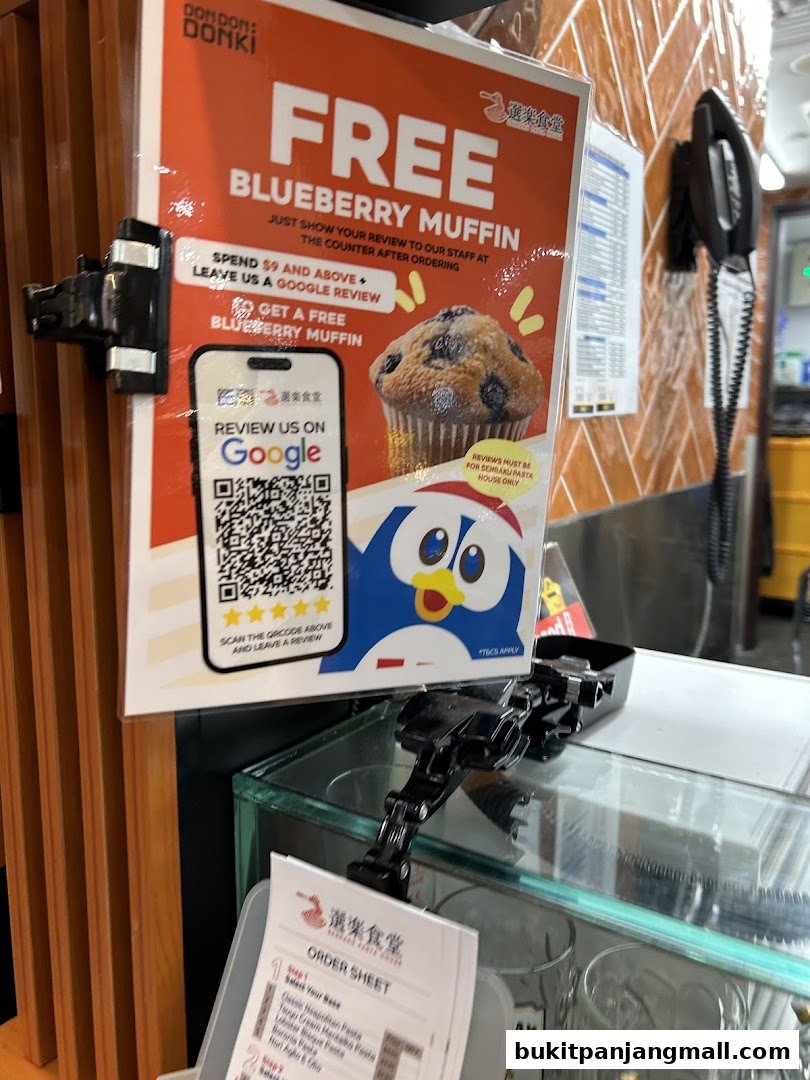 A promotional sign for a free blueberry muffin with a QR code for Google reviews.