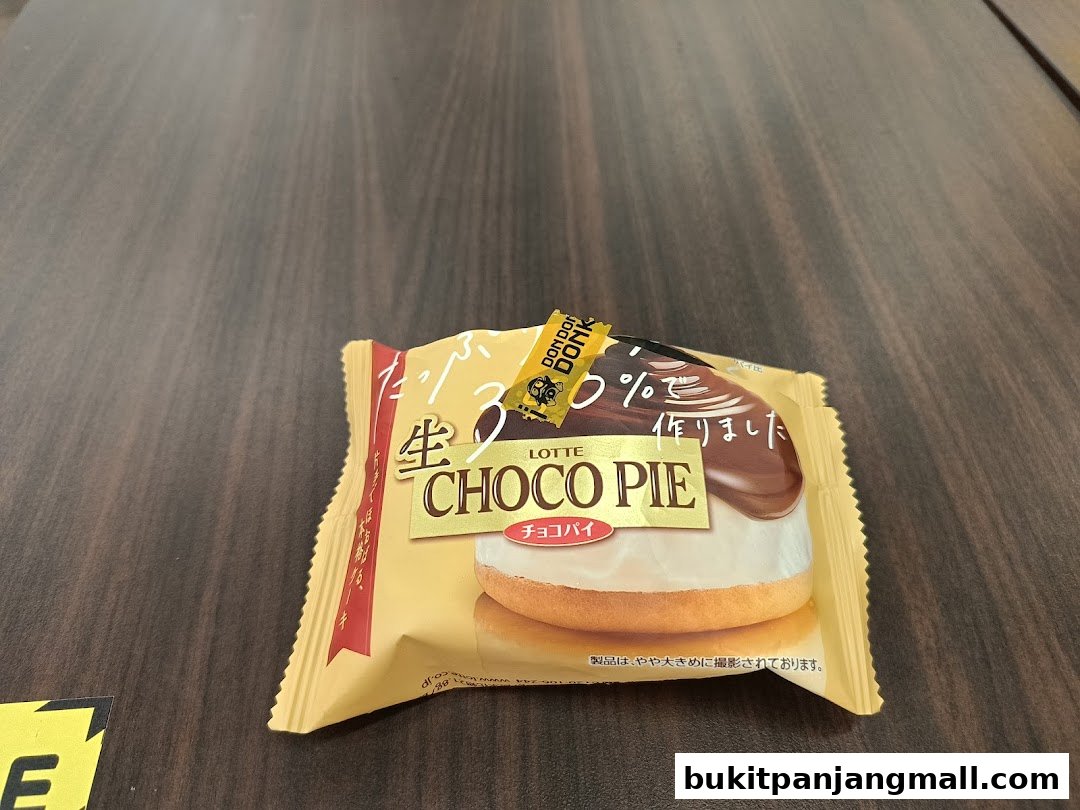 A Lotte Choco Pie snack on a wooden surface.
