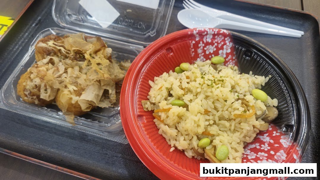 A close-up of two Japanese dishes, takoyaki and mixed rice, served in takeout containers.