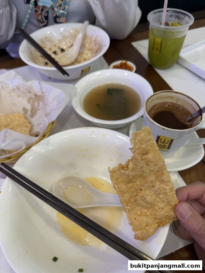A table setting with partially eaten food, drinks, and chopsticks.
