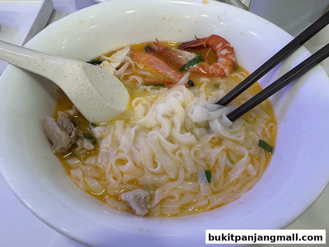 A close-up shot of a delicious bowl of Ipoh hor fun noodles with prawns and meat.