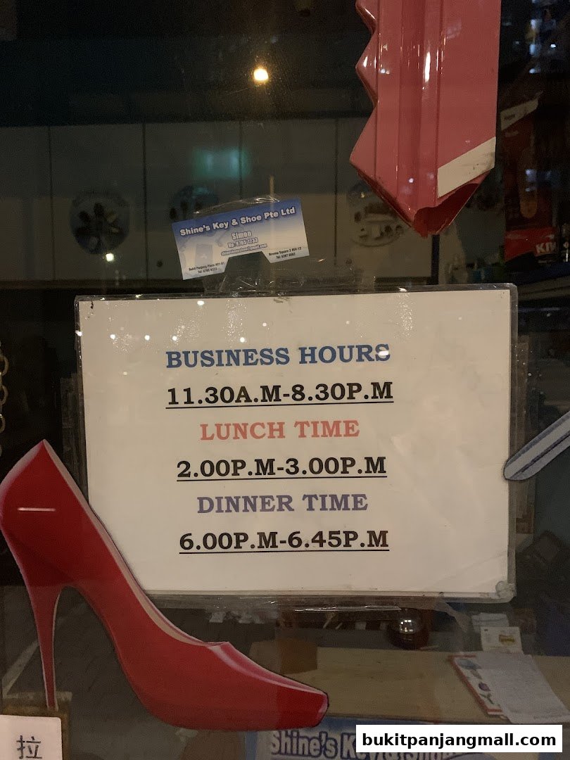 A sign displaying business hours for Shine's Key & Shoe Pte Ltd, with a red high heel cutout.