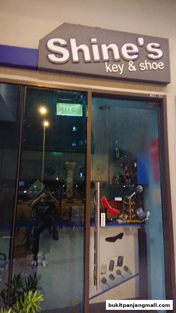 The storefront of Shine's Key and Shoe shop, featuring a display of keys and a red high-heeled shoe.